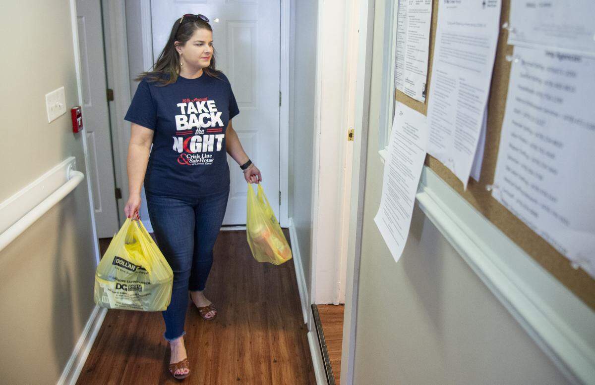 Suzanne Palmer, shelter director of Crisis Line & Safe House of Central Georgia, carries in groceries at the shelter.