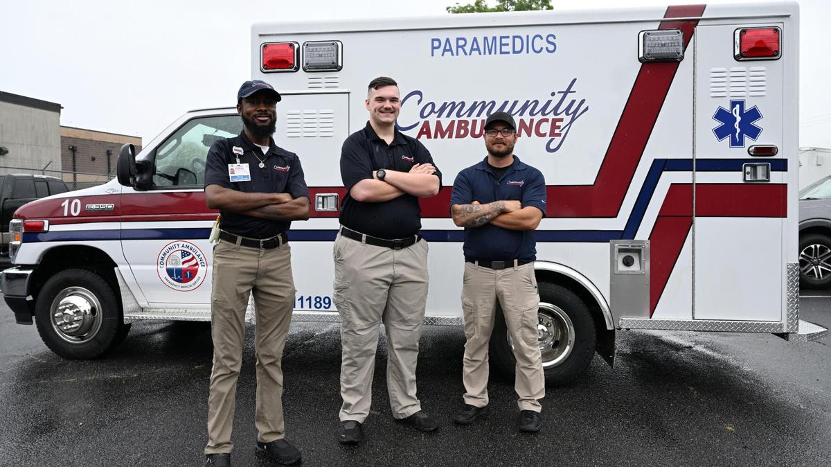 Community Ambulance paramedic Dominique Hodges (left), EMT Kole Adams (middle) and paramedic Jacob DiPaolo pose in front of an ambulance on Thursday, May 29, 2025, at the Community Ambulance office in Macon, Georgia. The two paramedics and EMT were posted at Lake Tobesofkee last Friday and responded to three children drowning.