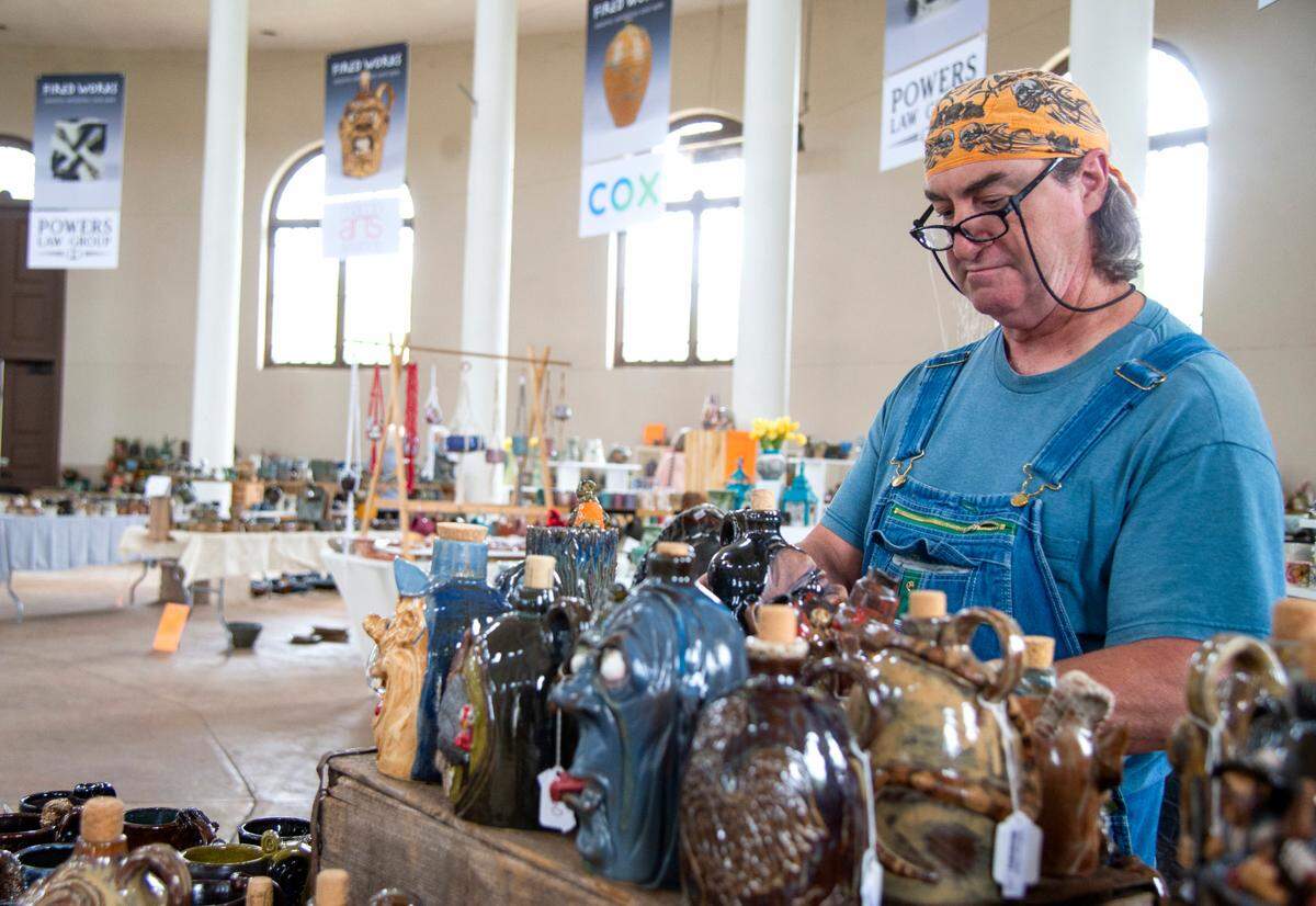 Glen Jones of Gray looks at pottery by artist Derek Belflower Friday during the Macon Arts Alliance “Fired Works” ceramic exhibition and sale at Carolyn Crayton Park. The show runs through April 17.