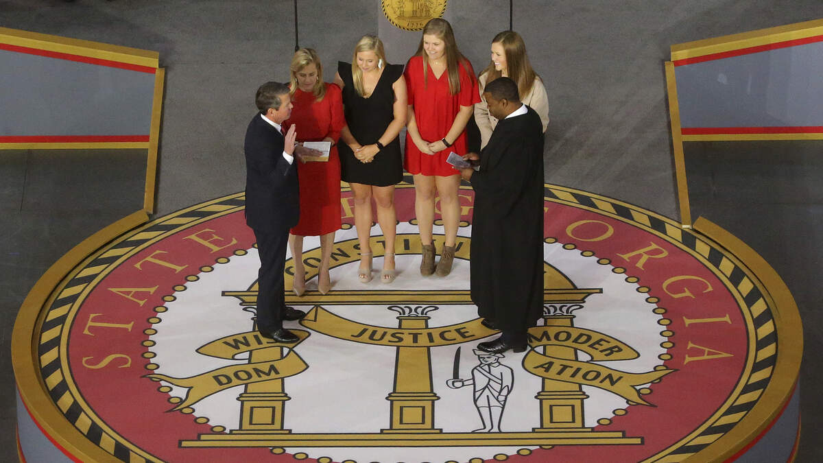 Brian Kemp, left, is sworn in as Georgia’s governor by Judge T.J. Hudson during a ceremony at Georgia Tech’s McCamish Pavilion on Monday in Atlanta.