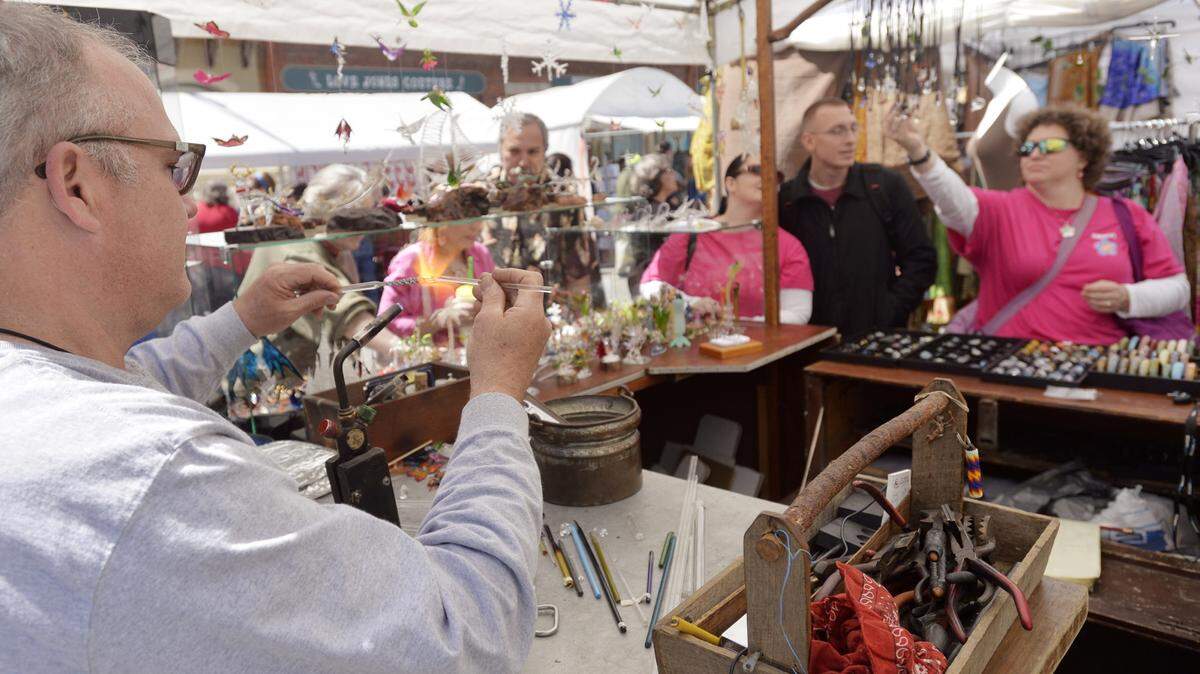 JASON VORHEES/THE TELEGRAPHCurtis Cecil of High Point, North Carolina, uses a flame to color glass at his booth during a previous year's Mulberry Street Arts and Crafts Festival.