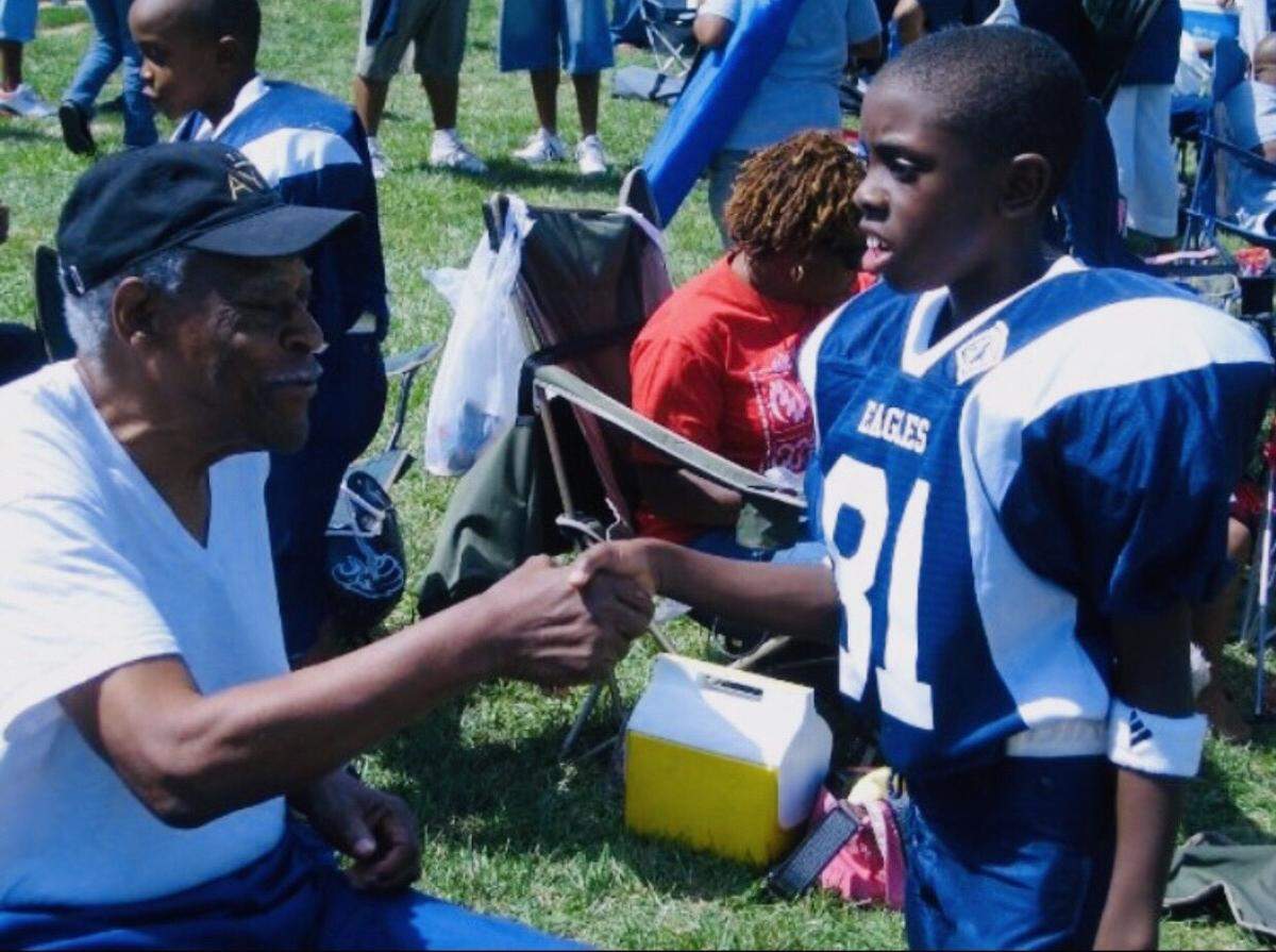 Roosevelt Webb (left) supported his grandson Mark Webb, Jr., in his Pop Warner days.