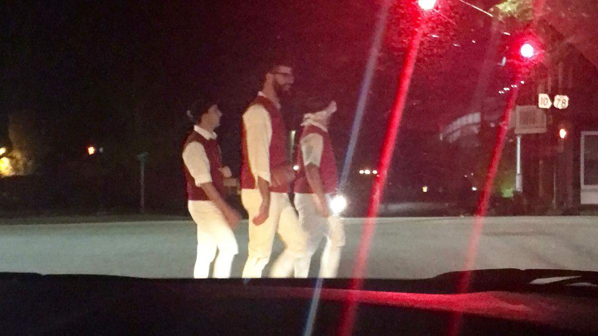 Three UMass Minutemen fans walk through downtown Athens. The trio are dressed as Minutemen from the American Revolution.