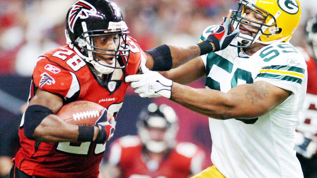 Falcon running back Warrick Dunn, left, runs off tackle around linebacker Na’il Diggs in this Telegraph file photo. Dunn is a member of the Georgia Sports Hall of Fame’s 2022 class.