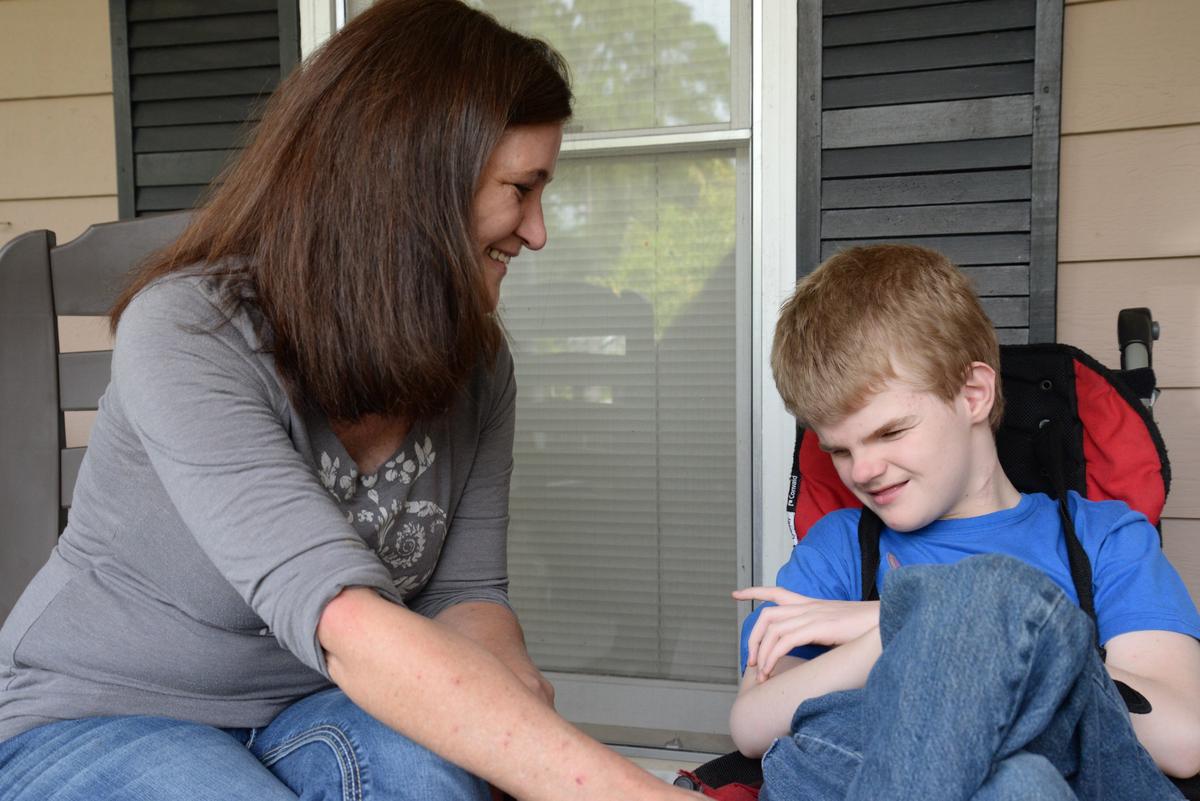 Leslie Johns, left, sits with her son, Darrell, on her older son’s front porch on Tuesday. Darrell was born with hydrocephalus and epilepsy, which are neurological conditions that have stunted his development and cause seizures. Johns said medical marijuana has significantly benefited his health.