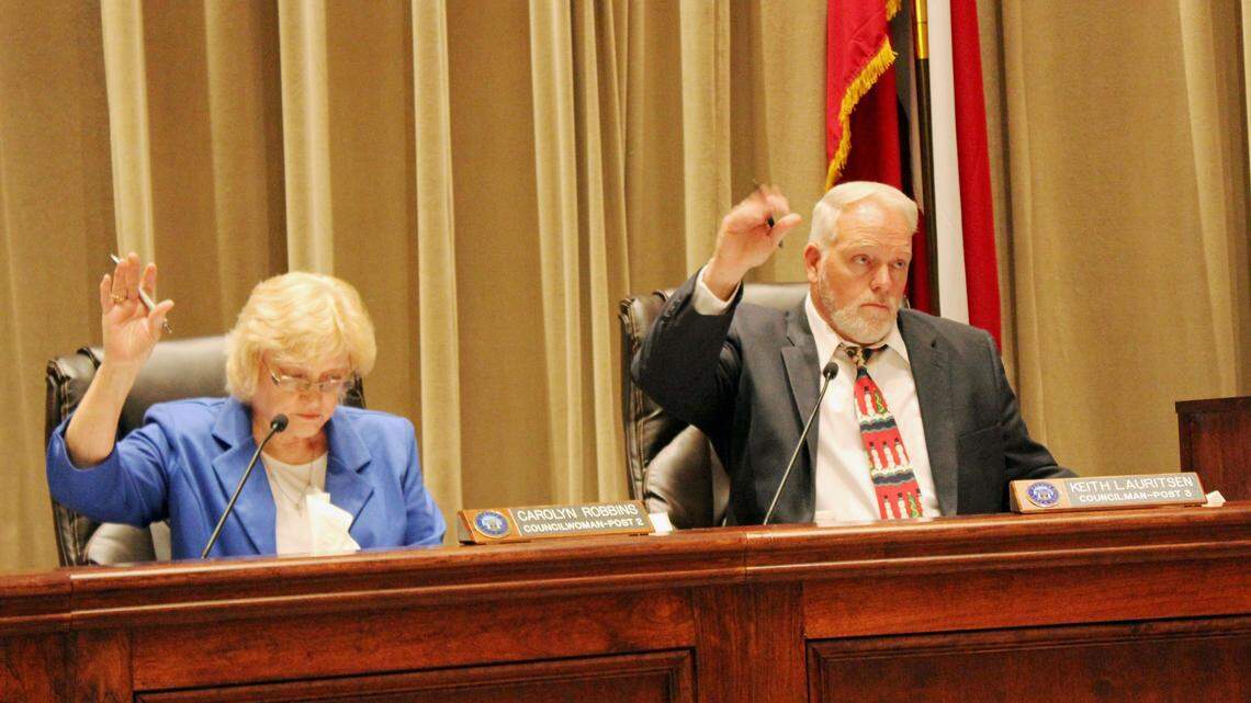 Warner Robins council members Carolyn Robbins and Keith Lauritsen vote in favor of a resolution giving the mayor the authority to negotiate details of an agreement in which the city will partner with the board of education to build a $3 million tennis facility.