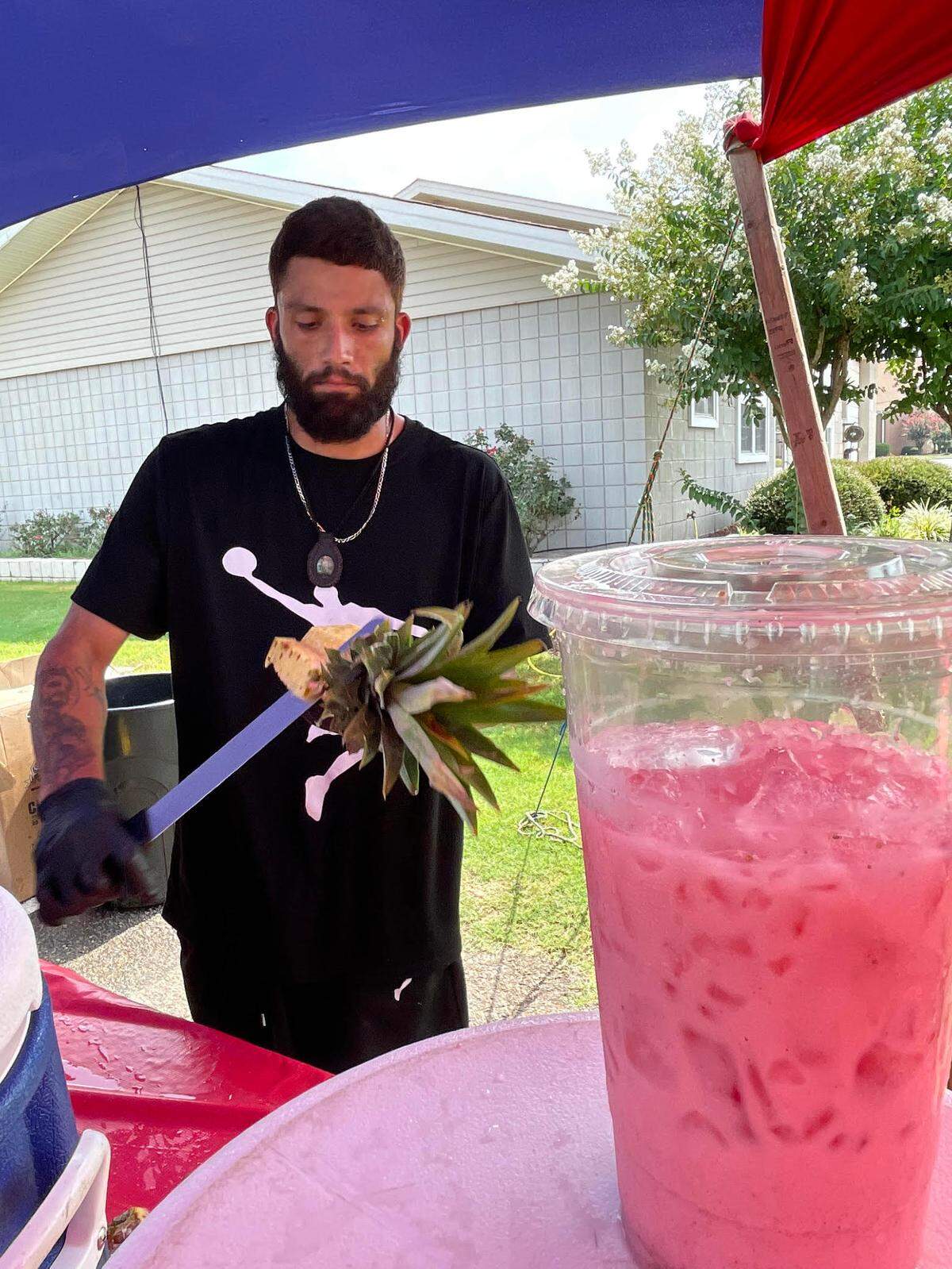 Jesus Villalon, owner of Aguas Frescas Los Cholos, slices up a pineapple at the stand at Moody and Sandy Run roads in Warner Robins.