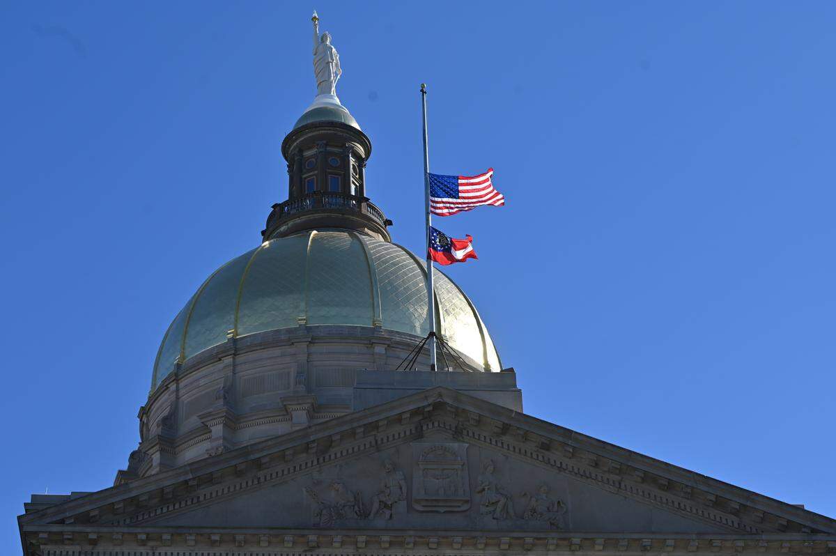 An American flag and the Georgia state flag hang at half-staff to honor former Georgia governor and U.S. president Jimmy Carter outside of the Georgia State Capitol on Saturday, Jan. 4, 2025, in Atlanta, Ga. Carter died on Sunday, Dec. 29, 2024, and will be honored with ceremonies throughout the state in the coming week.
