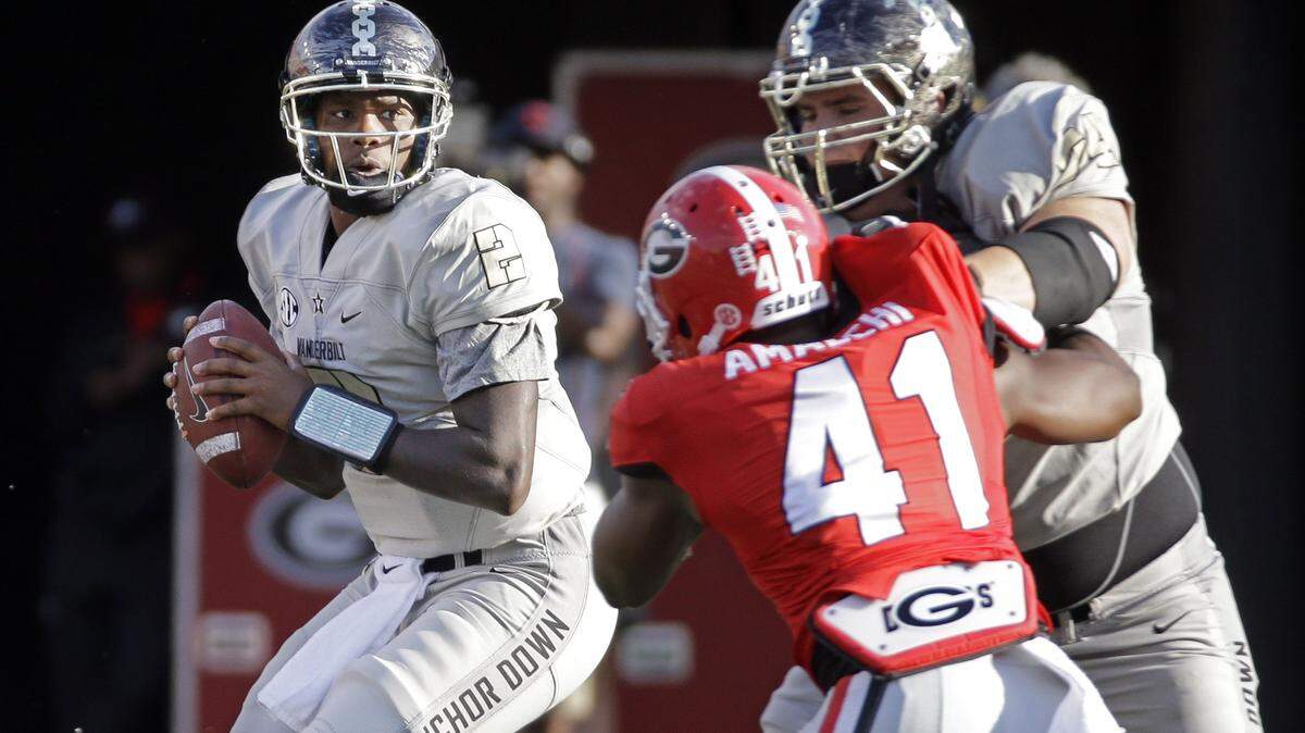 Vanderbilt quarterback Johnny McCrary (2) looks for a receiver as offensive tackle Will Holden, right, blocks Georgia linebacker Chuks Amaechi (41) in the second half of an NCAA college football game Saturday, Sept. 12, 2015, in Nashville, Tenn. Georgia won 31-14. (AP Photo/Mark Humphrey)