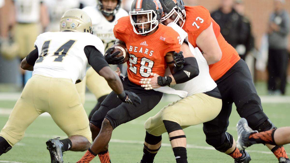 Mercer running back Tee Mitchell (28) gets hit by the Wofford defense at the line of scrimmage during their game Saturday night.