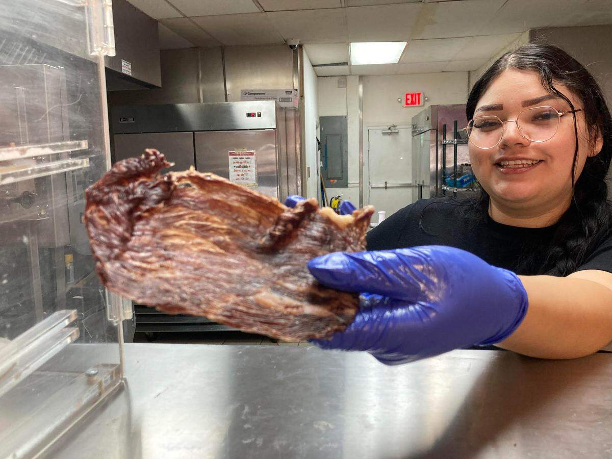 Cristal Castro holds up house-made beef jerky at Carniceria Tienda Don Sammy, a new Mexican butcher shop and grocery store in Warner Robins from the same family behind the authentic Mexican restaurant Taqueria Don Sammy.