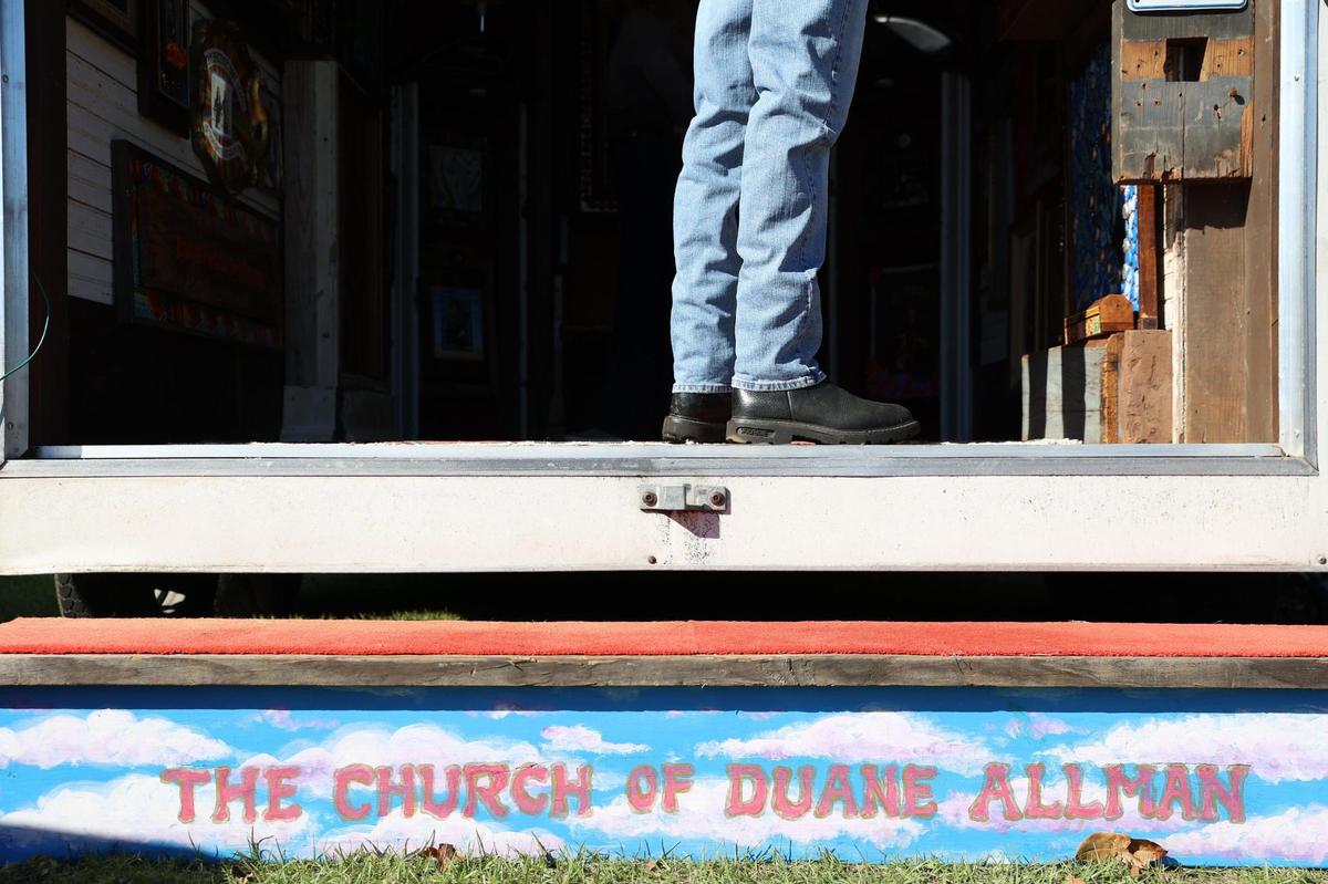 An attendee at Skydog Festival looks inside of The Church of Duane Allman on Sunday, Nov. 24, 2024, at Carolyn Crayton Park in Macon, Georgia. John Mollica created The Church of Duane Allman art exhibit to showcase his art and share the legacy of guitarist and front man of The Allman Brothers Duane Allman, a key figure in Macon music history.