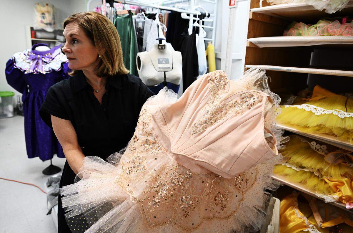 Nutcracker of Middle Georgia board member Amy Green pulls the Sugar Plum Fairy costume out of its storage shelf during a studio tour. Many of the production’s costumes were updated to honor the milestone season. 