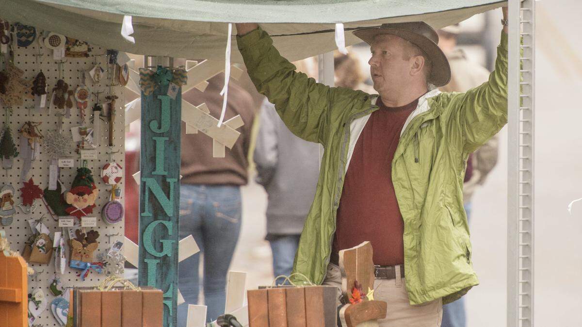 JASON VORHEES/THE TELEGRAPH Juliette, GA, 11/0 1/2015: 
 Matt Crist of Macon lifts the canopy on his wife Nahcole's booth while trying to remove water during the Green Tomato Festival Sunday in Juliette.