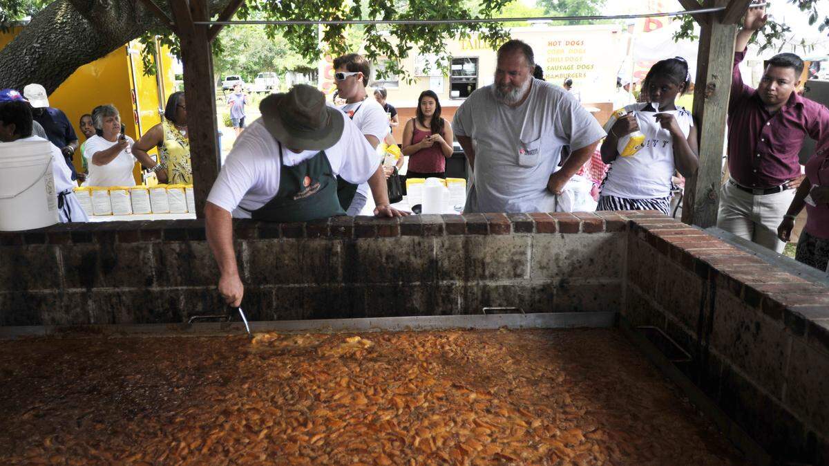 The huge peach cobbler, the centerpiece of the Peach Festival, gets a last check before serving in this 2013 file photo.