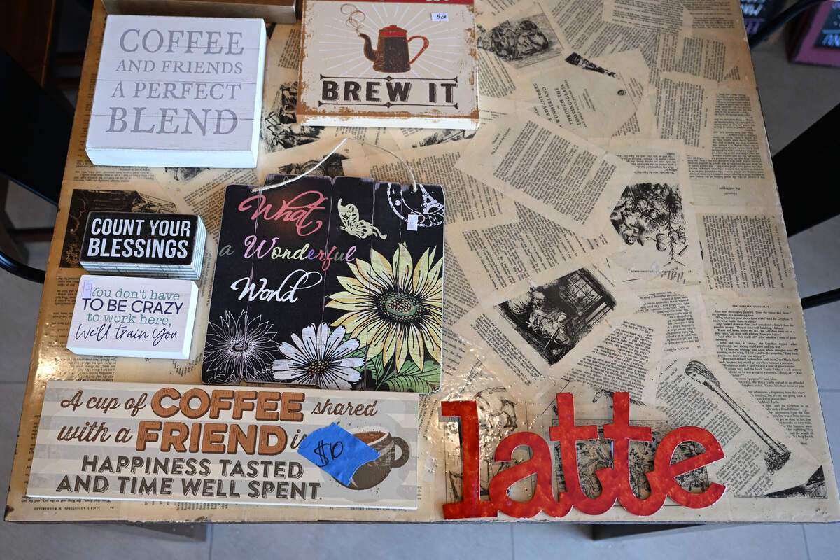 Signs labeled with prices on a table inside Between Friends Coffee in Warner Robins on Wednesday, June 10, 2026, ahead of its liquidation sale Monday, June 15, 2026.