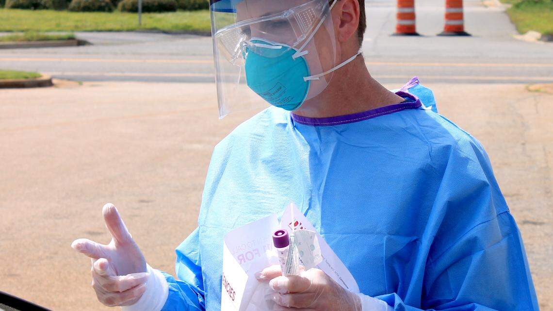 Photo courtesy of North Central Health District A nurse with the North Central Health District uses personal protective equipment while demonstrating a COVID-19 test at a Houston County testing site.