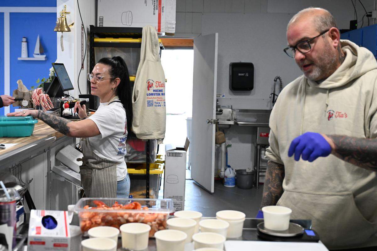 Tia Small (left) takes orders while her husband Chris Small portions out lobster into cups at the couple’s takeout restaurant, Tia’s Maine Lobster Rolls, in Warner Robins. The husband and wife moved to Warner Robins from Maine and opened their take out restaurant in early November.