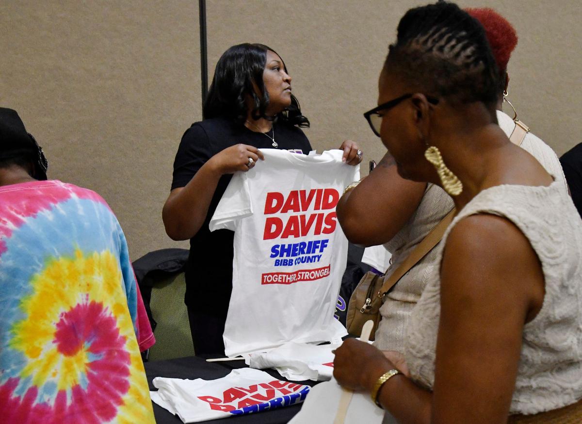 Rho Alpha Tau member Latesha Jones holds up a David Davis campaign shirt at Davis’ reelection celebration on Thursday, May 30, 2024, at the Edgar H. Wilson conference center in Macon, Georgia. Davis held the event to commemorate his reelection into a fourth consecutive term as Bibb County Sheriff.