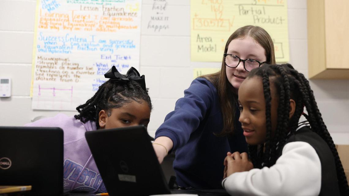 Student Jordan Pearson (middle) helps two students with an assignment in class on Monday, Feb. 24, 2025.