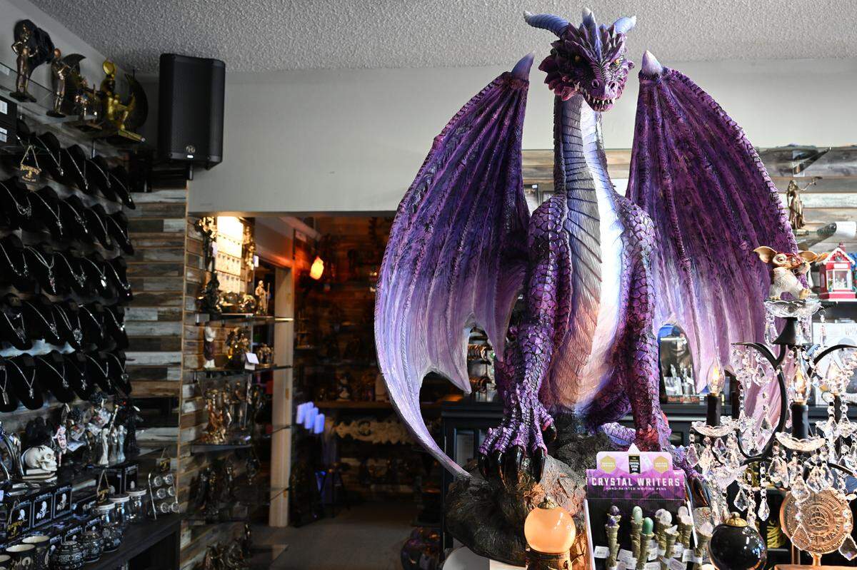 One of two large purple dragon statues sits near the register at The M Cave in Centerville. Robin Lianos, who owns the shop with her husband, Stefanos, said each dragon weighs 258 pounds and took four people to move.
