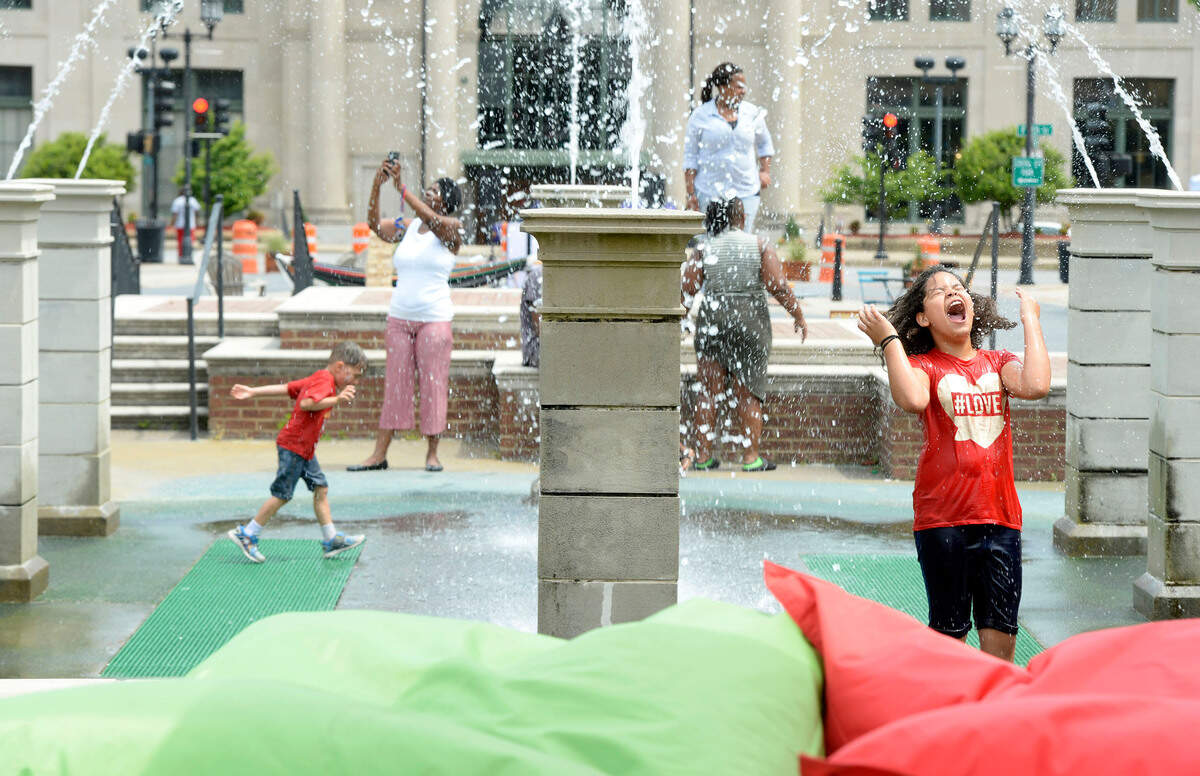 Aniyah Mullis, 8, right, said she was staying cool May 5 at the Cherry Street Pop-Up Plaza splash pad. “I love the water,” she said as temperatures rolled into the mid-80s. The New Town initiative--complete with live entertainment, a superhero costume contest for dogs and kids, and an artisan market--was designed to showcase Cherry Street offerings, according to project manager David Moore.