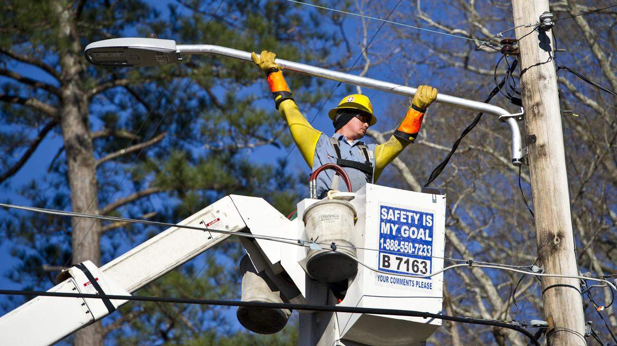 Ben Gore with Utility Line Construction Services installs a new LED street light on Gwinett Drive this week.