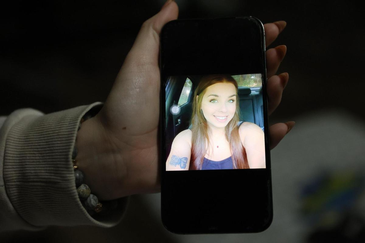 Ashley Otto holds up a picture of her sister Victoria “Tori” Otto on her phone showing a butterfly tattoo in their family home on Wednesday, Feb. 26, 2025, in Milner, Georgia. Ashley Otto plans to honor her sister’s life by getting the same butterfly flower tattoo that Victoria Otto had.