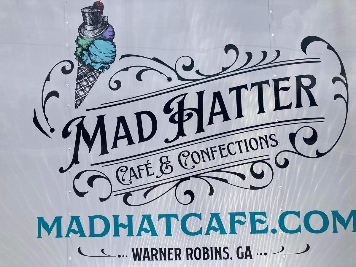 The Mad Hatter Cafe & Confections logo pictured on a the side of trailer the owners use for storage and advertising.