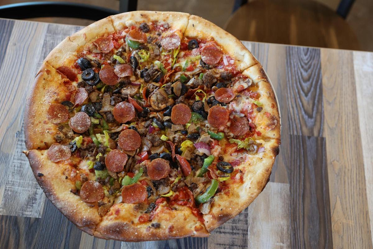 Amici’s supreme pizza, called “The Works,” sits on a table in the Perry location of Amici on Wednesday, Oct. 16, 2024, in Perry, Georgia. The new Perry location of Amici is set to open to the public on Monday and will be Perry’s first brewery.