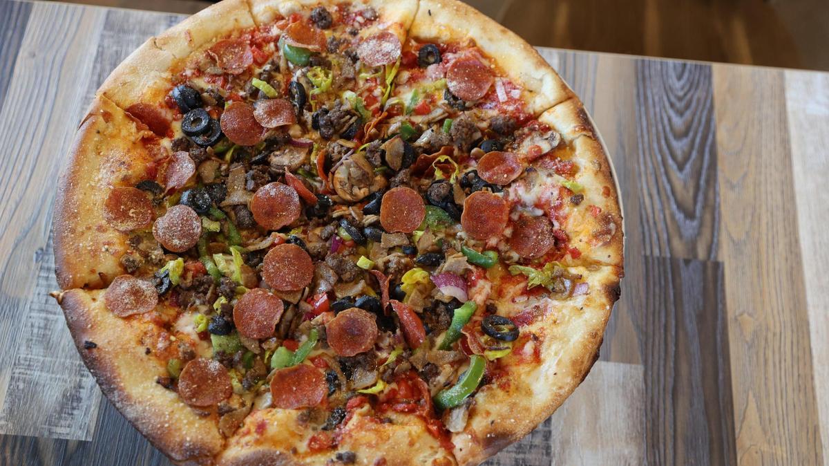 Amici’s supreme pizza, called “The Works,” sits on a table in the Perry location of Amici on Wednesday, Oct. 16, 2024, in Perry, Georgia.