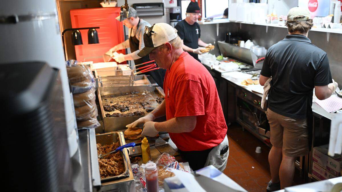 Fincher’s Barbecue co-owner Jake Fincher completes orders with kitchen staff at the new Warner Robins location, Friday, May 15, 2026. The new location on South Armed Forces Boulevard across from Robins Air Force Base replaces the former Davis Drive restaurant.