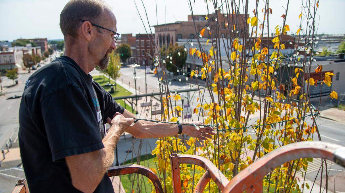 Bryan Nichols hangs Christmas lights atop a Princeton elm tree in Proudeit Park along Poplar Street park Monday morning in preparation for the Main Street Christmas Light Extravaganza. Nichols started putting up the lights Saturday and will hang lights on 130 trees before the light display kicks off with a Macon Pops concert on Nov. 25.