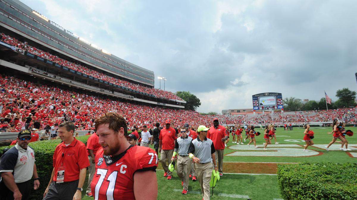 Georgia offensive lineman John Theus (71), his teammates and the Georgia cheerleaders make their way to cover after lightning was detected in the vicinity during the second half Saturday against Louisiana-Monroe.