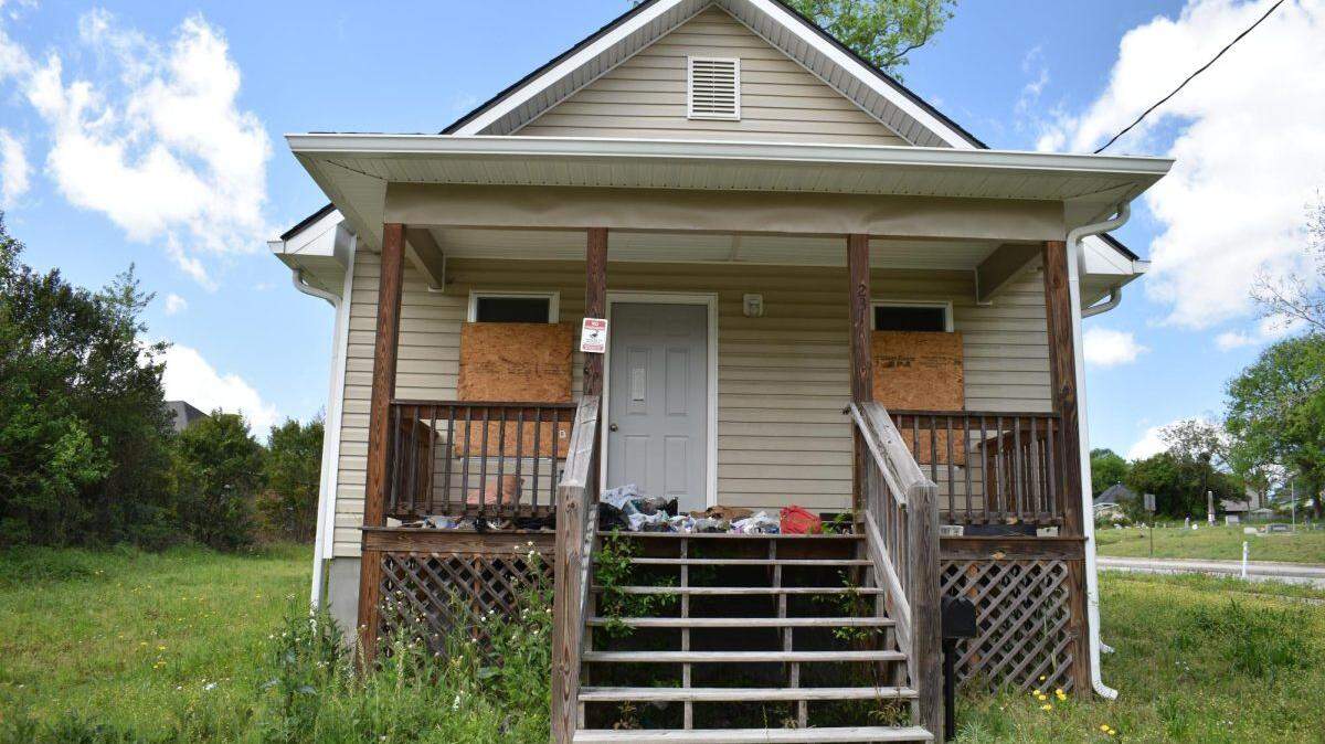 The Macon-Bibb County Community Enhancement Authority built this house at 231 Moughon Street Lane in 2020. Four years later, it is vacant with trash on the porch, boarded up windows and tall grass.