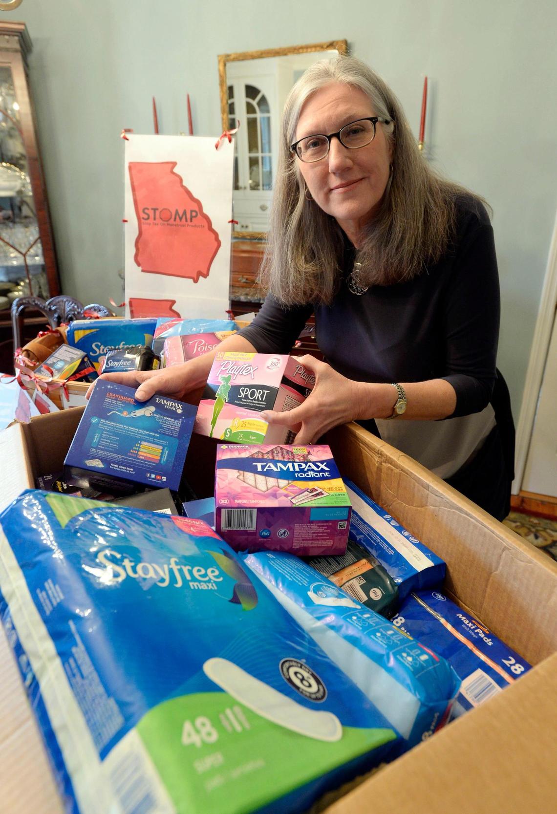 Claire Cox packs up a box of donated menstrual products that her organization STOMP, or Stop Tax on Menstrual Products, gives away at schools. Cox has been trying to get Georgia legislators to end sales taxes on such products.