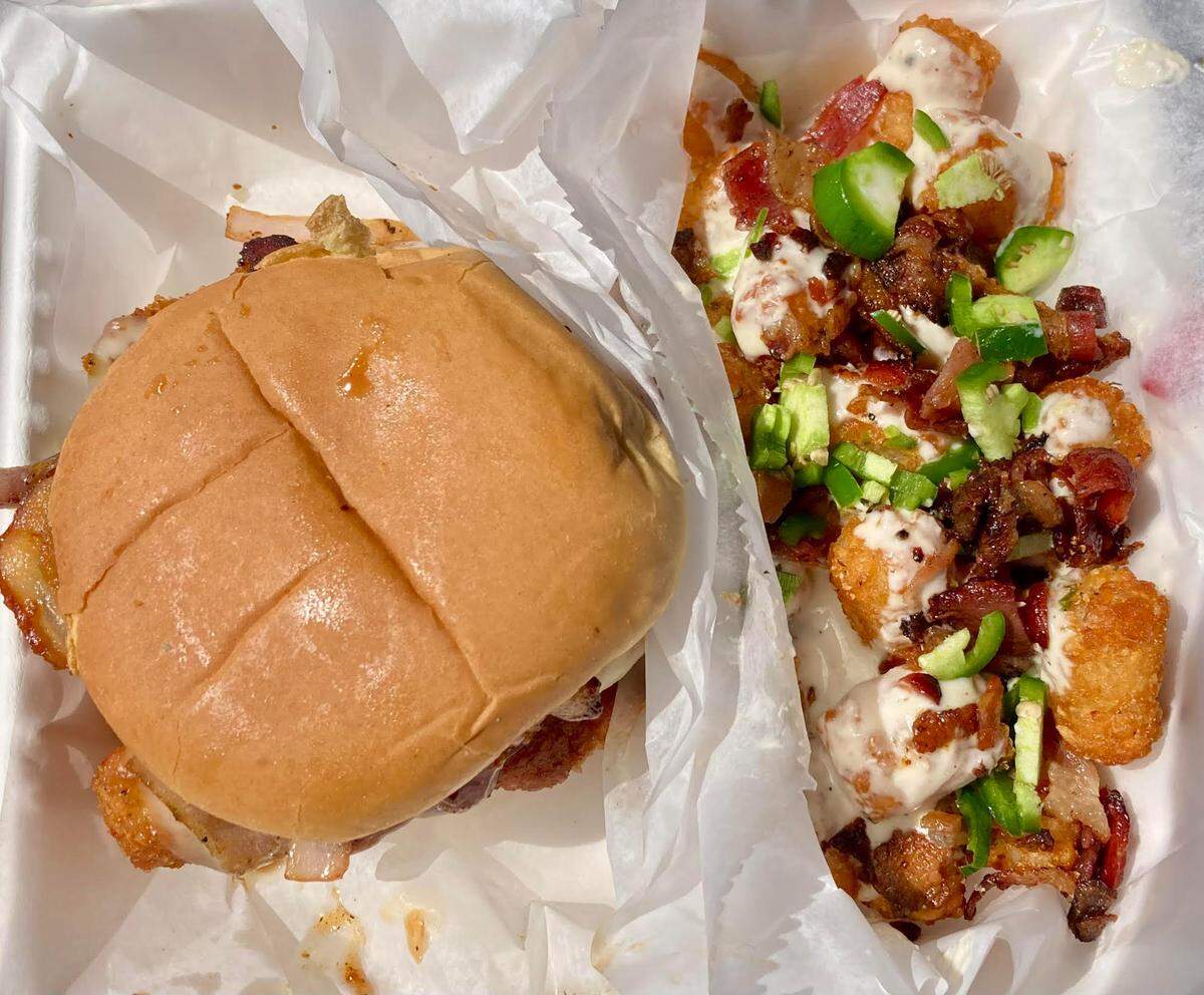 Bearfoot Tavern food truck’s kickin’ chicken sandwich, described on the menu as a fried chicken tender sandwich with Swiss cheese, kickin’ bourbon BBQ sauce, grilled onions and bacon, with loaded tots that are topped with beer cheese, bacon and jalapenos.