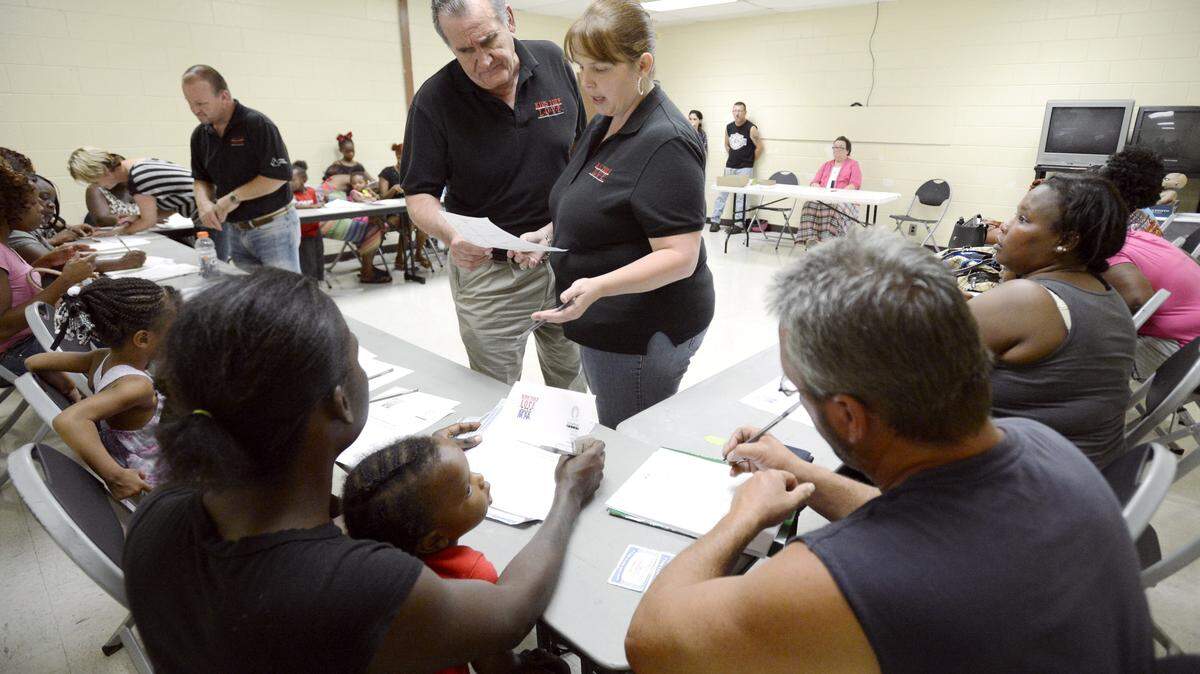 JASON VORHEES/THE TELEGRAPH Macon, GA, 09/03/2015: 
 Kids Yule Love CEO Joe Allen and director of Jones County Spring Craven look over an application during a registration event at the Bloomfield Recreation Center.