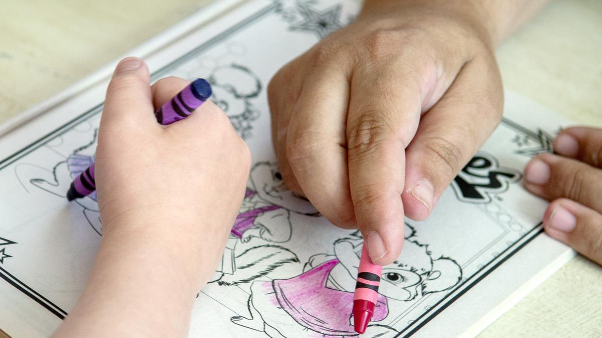 A Georgia woman colors at her home with her 6-year-old foster child.