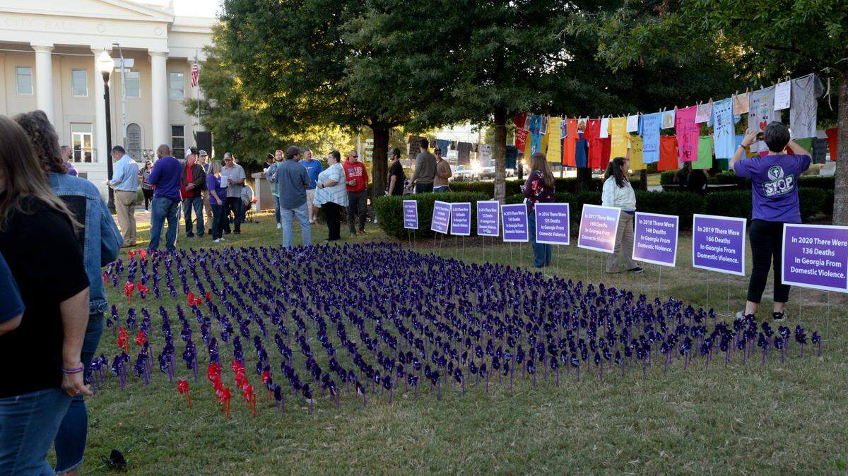 People gathered in Rosa Parks Square Tuesday night for a candlelight vigil for Domestic Violence Awareness Month.