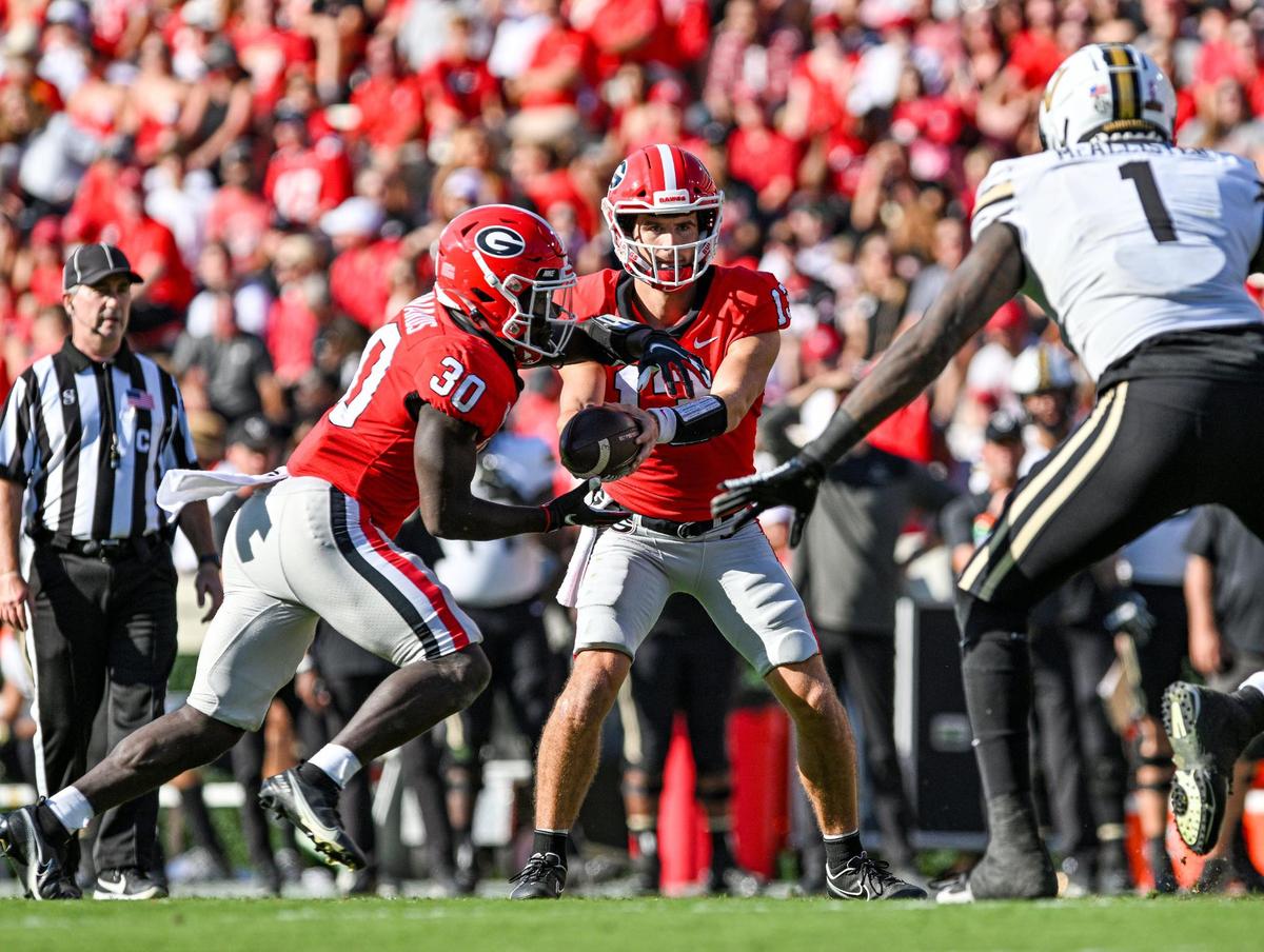 Georgia quarterback Stetson Bennett hadns off the ball to running back Daijun Edwards in action Saturday as the Dawgs beat Vanderbilt 52-0.