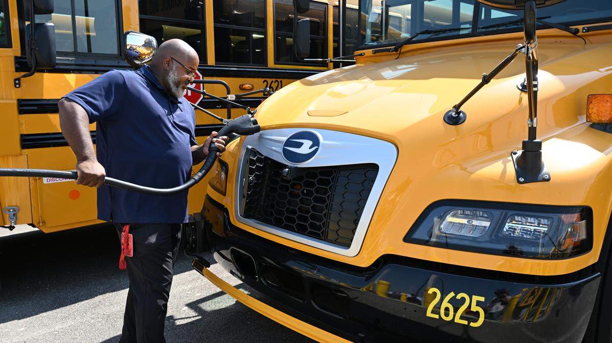 Bibb County School District bus driver Clarenza Payton unplugs an all-electric school bus from its charger at the district bus depot in Macon, Ga. Fifteen all-electric buses were added to the district’s fleet, marking a first for BCSD.