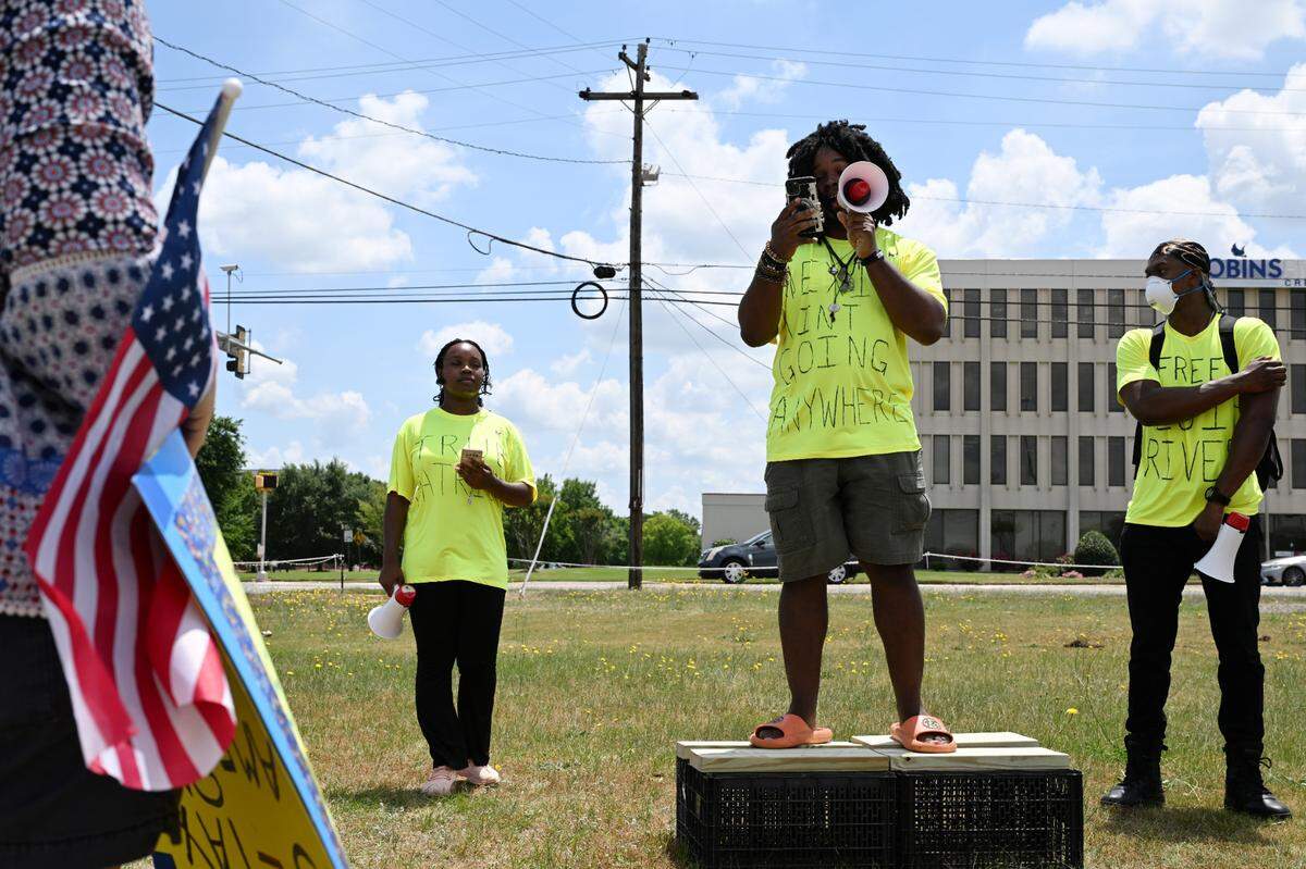 Organizer Teon Lockett, 24, from Warner Robins (middle) gives a speech before the start of a march down Watson Boulevard to Warner Robins City Hall on Wednesday, April 30, 2025, in Warner Robins, Georgia. Around a dozen people gathered to protest against the Trump administration’s immigration policies.