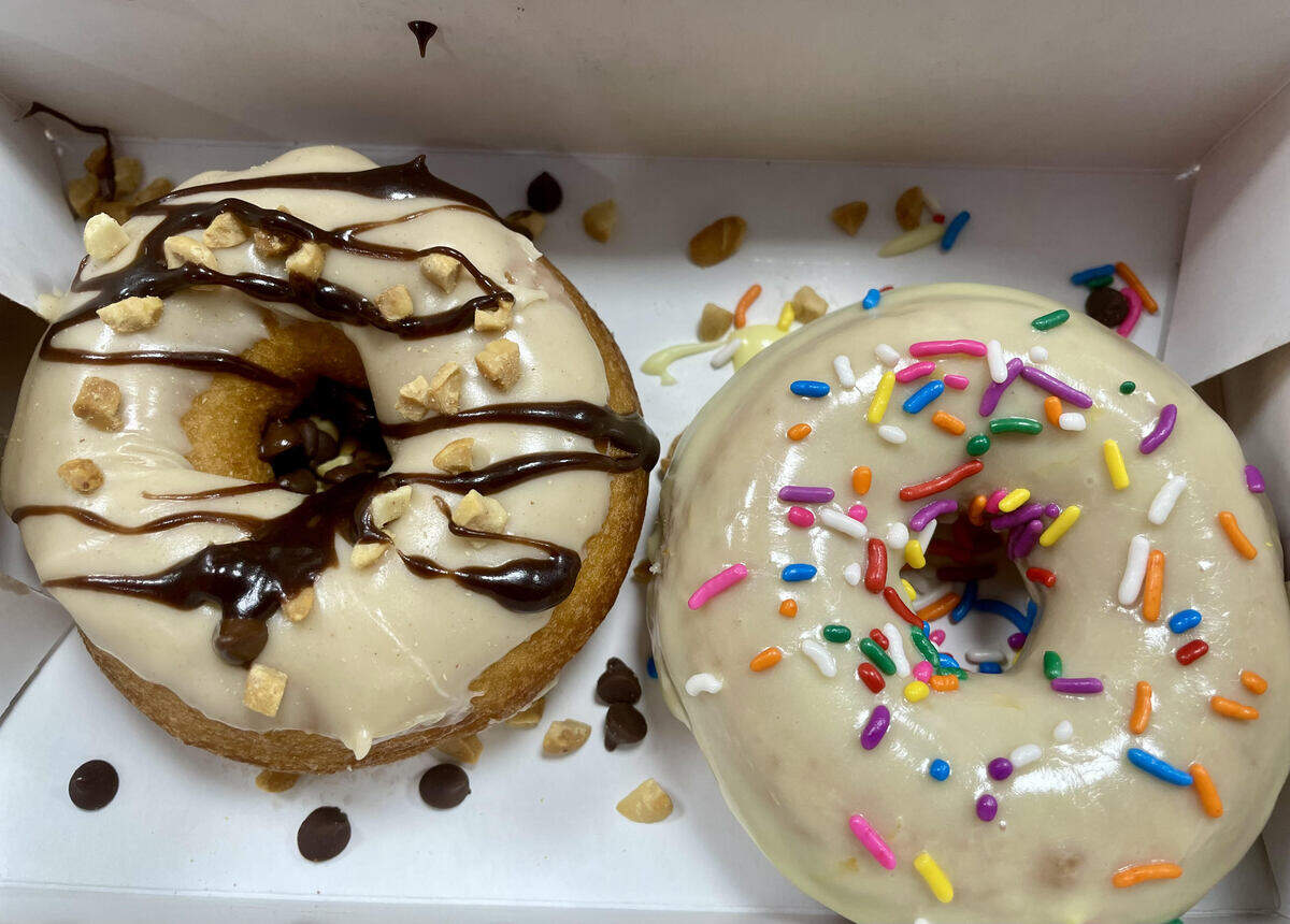 Two fresh warm doughnuts to-go from the new Duck Donuts in Warner Robins where customers may choose their coatings, toppings and drizzle. From left to right, a doughnut topped with peanut butter, chopped peanuts, mini chocolate chips and drizzled with chocolate icing and a doughnut with lemon icing and sprinkles.