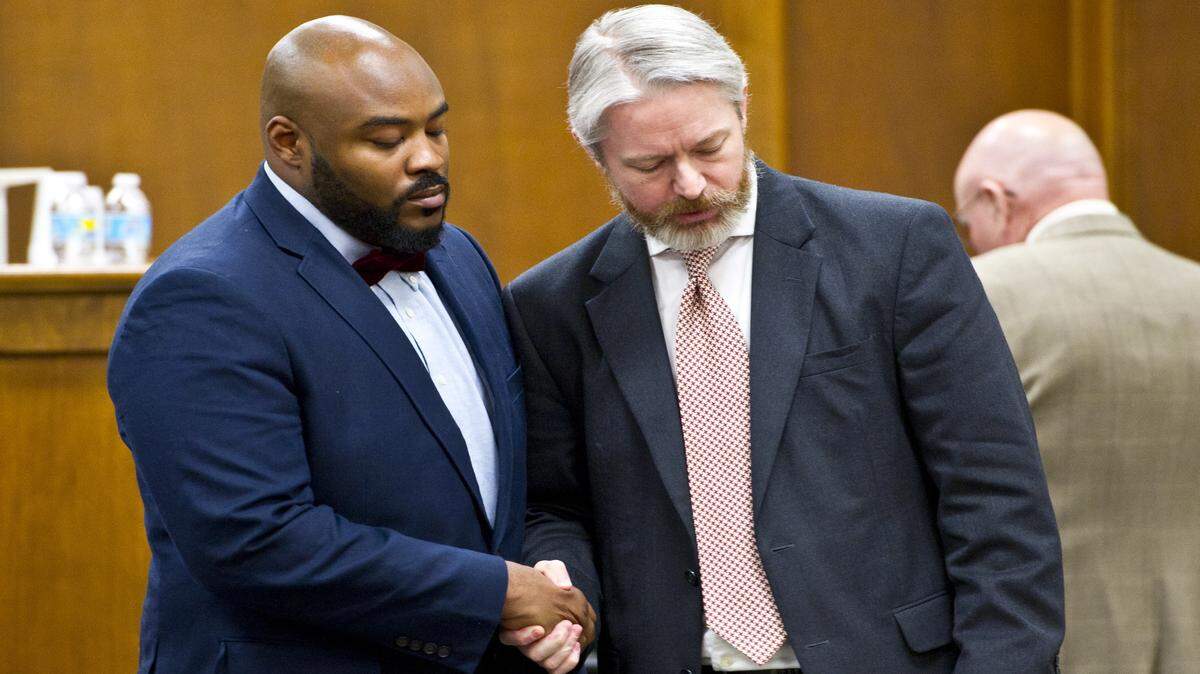 Andre Pope, 25, a former Bibb County Sheriff's Office corrections officer, shakes hands with his attorney, John Cater, in court Friday morning. Pope was sentenced to 10 years, three of them in prison Friday, after he pleaded guilty to providing two cellphones to inmates at the county jail.