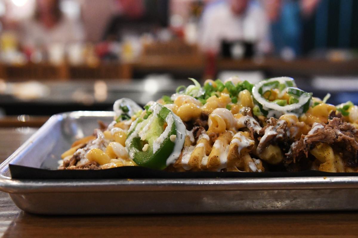 Chipotle mac and brisket fries sit on the bar at Piedmont Brewery & Kitchen on Wednesday, July 10, 2024, in downtown Macon, Georgia. Piedmont Brewery & Kitchen was one of 20 locations in the 3rd annual Downtown Macon French Fry Fight, where each participating restaurant creates a unique french fry special for the day in competition with other local restaurants.