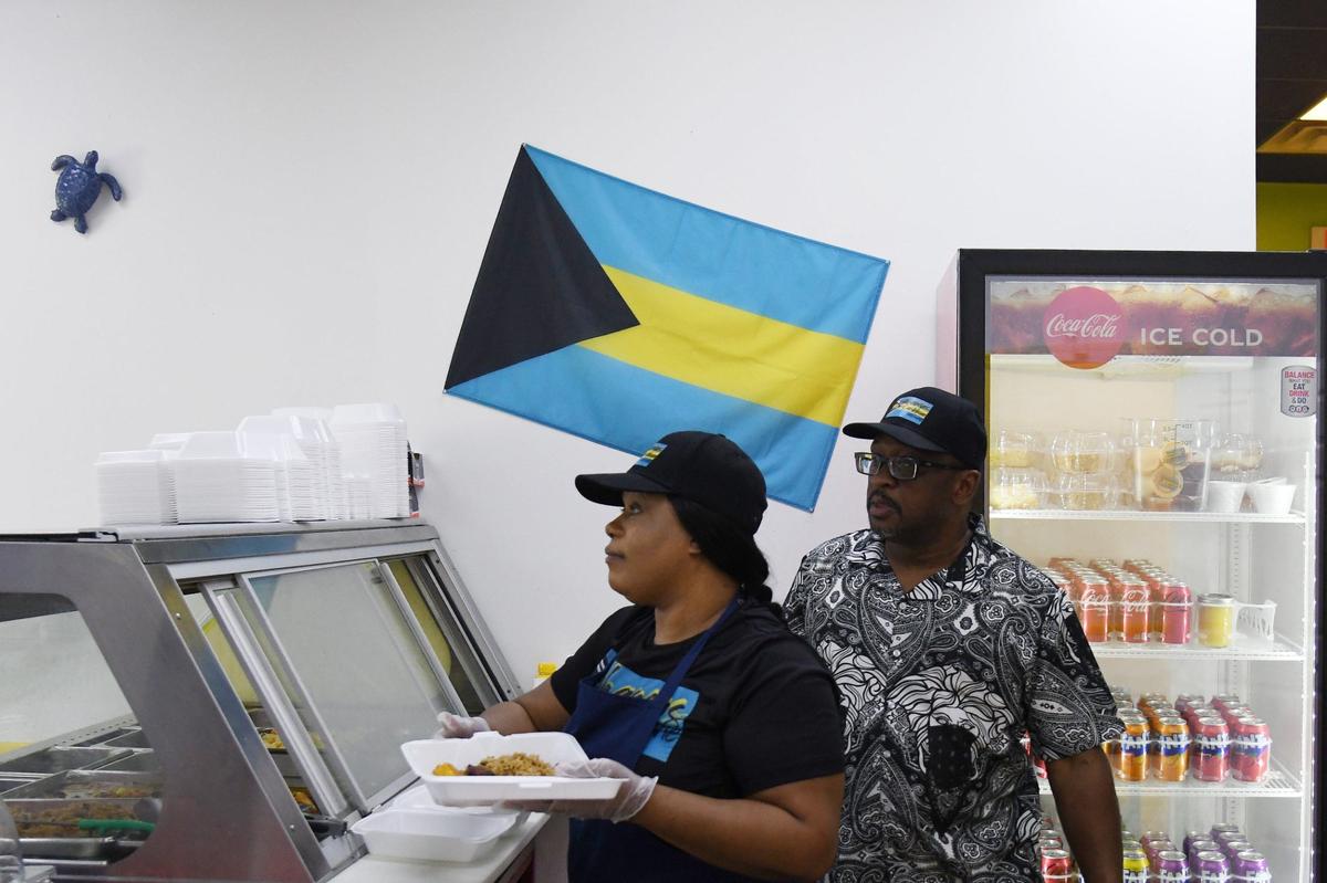 Bahamas Caribbean Cuisine owners Walt Williams and his fiancee Shantel Major (left) plate food at their restaurant on Thursday, Aug. 15, 2024, in Warner Robins, Georgia. The new restaurant serves authentic Bahamian food.