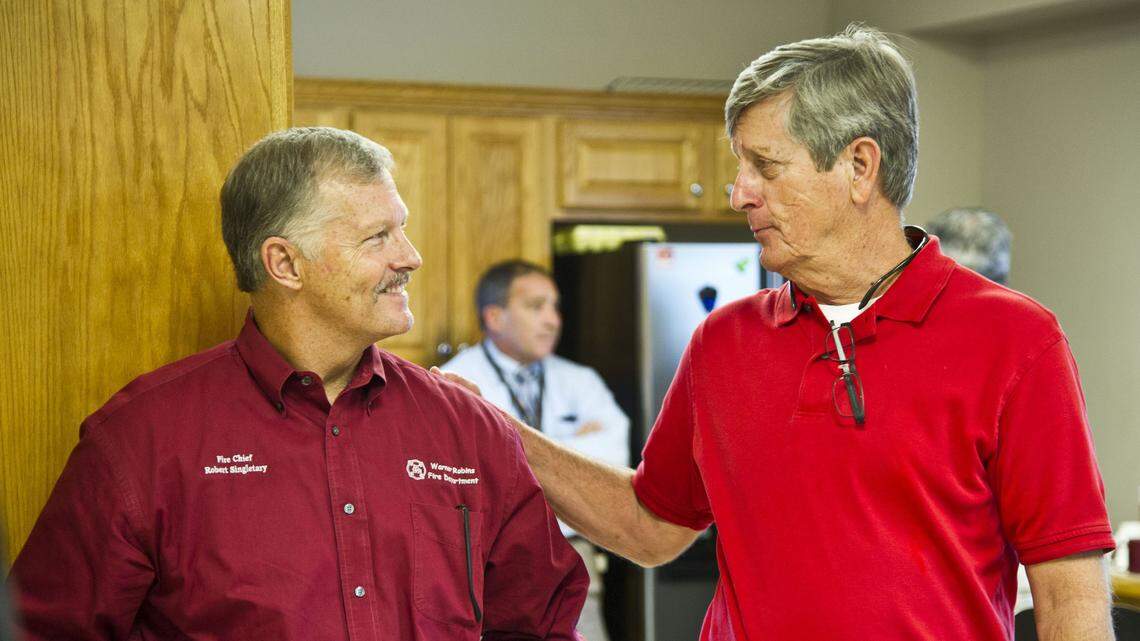 Warner Robins City Clerk Bill Harte, right, greets Fire Chief Robert Singletary at a retirement reception for Singletary on Sept. 7, 2016. Harte announced Monday he has resigned.