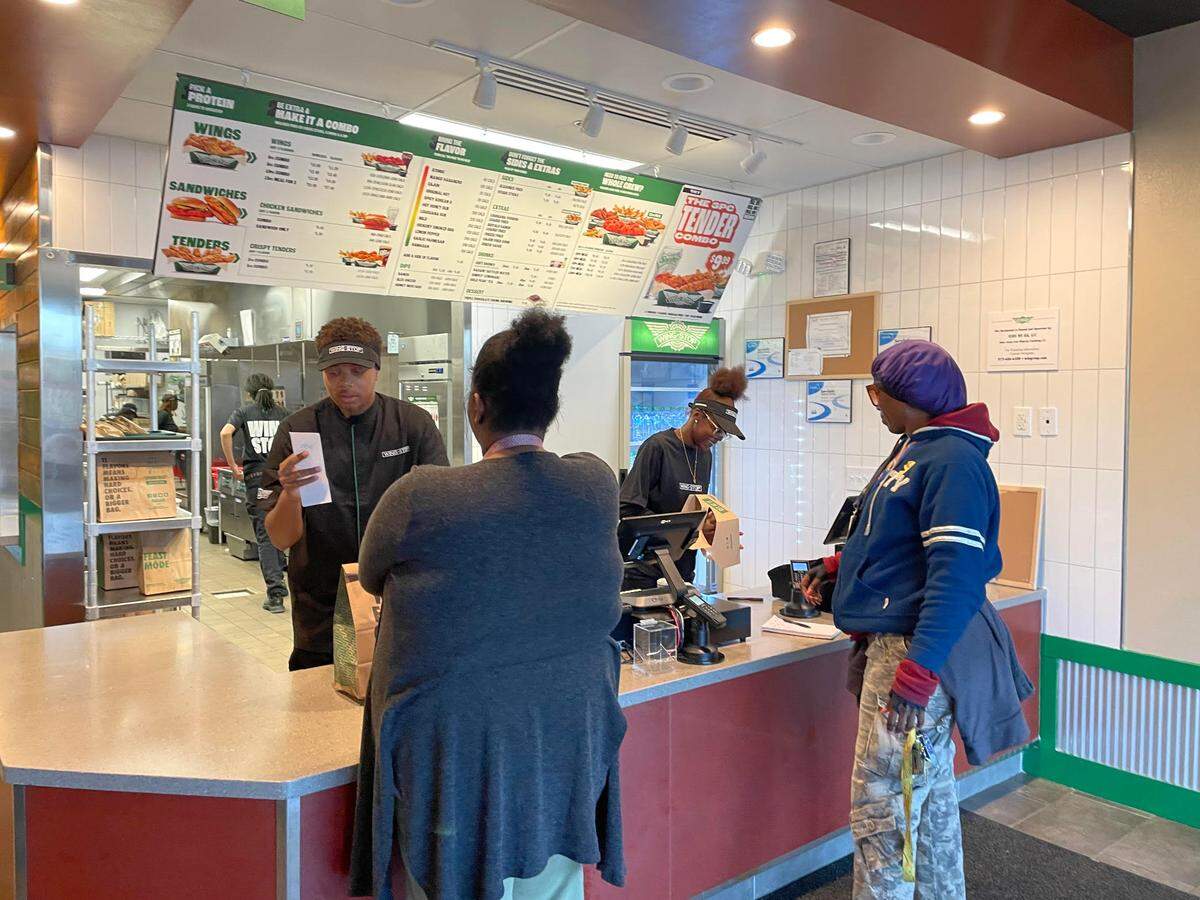 Customers at the order and pickup counter at the new Wingstop in Perry.