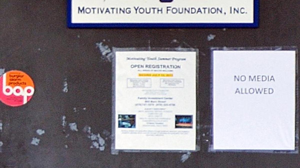 A sign on the door of the Motivating Youth Foundation reads "No media allowed.”